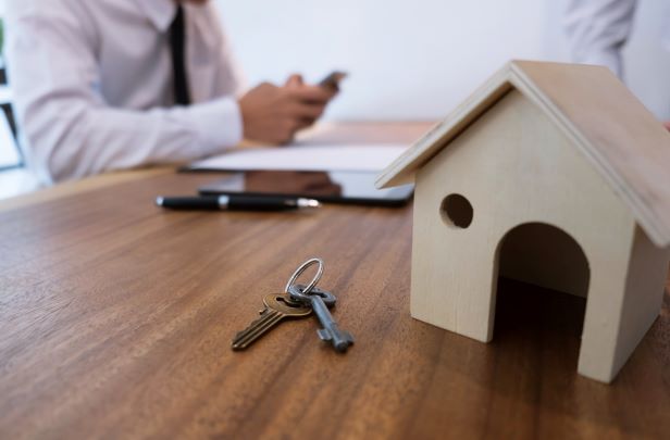 business discussion with small handmade wood house with keys on wood table