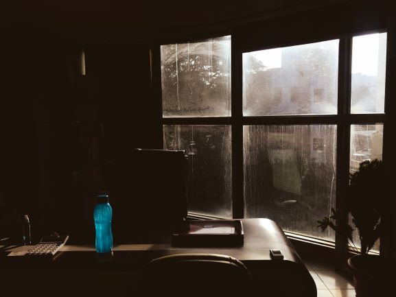 Blue Plastic Tumbler on Wooden Table Beside Chair in Room