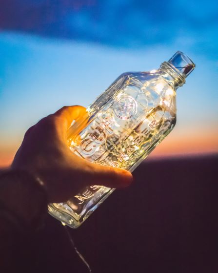 empty glass bottle in hand