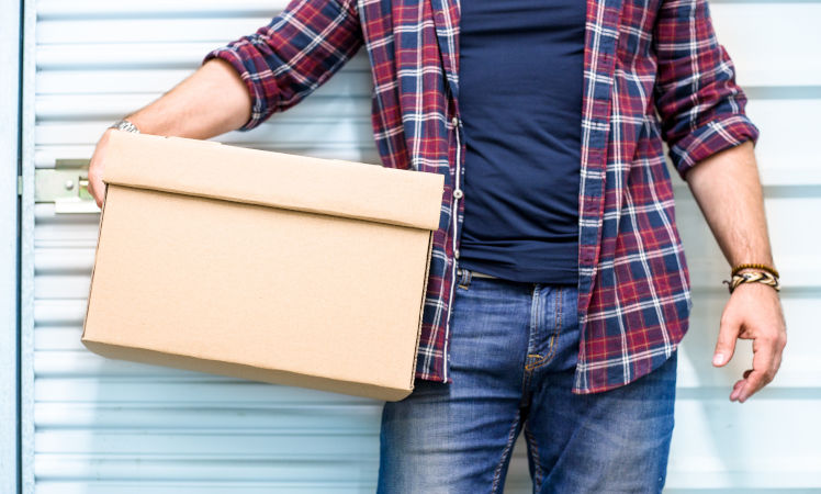 Man depositing box in a storage space facility